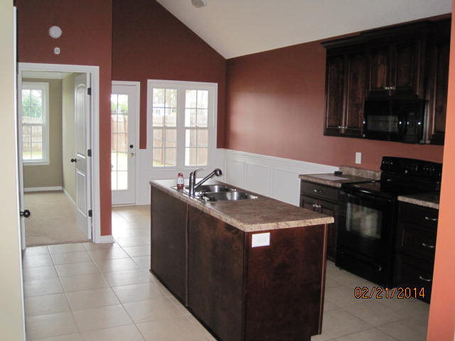 419 Bob White Road Macon, GA 31216 - Photo 6 of 13 a kitchen with a sink and a stove top oven with wooden floor