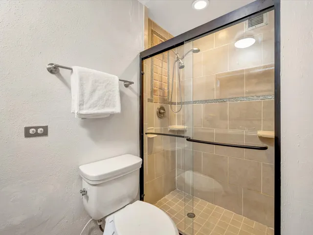 a bathroom with a granite countertop sink mirror vanity and toilet