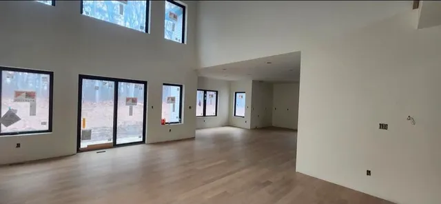a view of a big room with wooden floor and windows