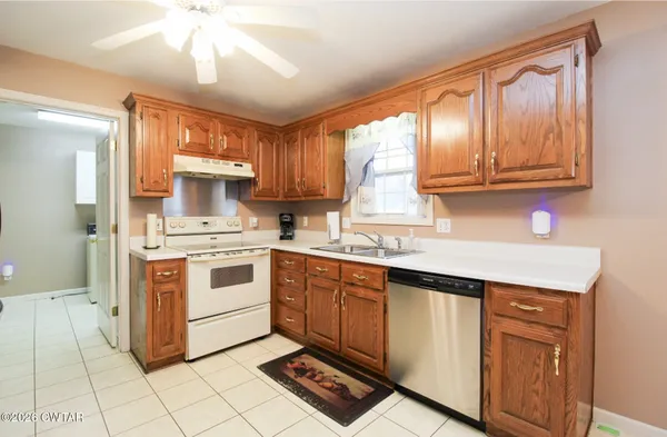 a kitchen with granite countertop a stove sink and cabinets