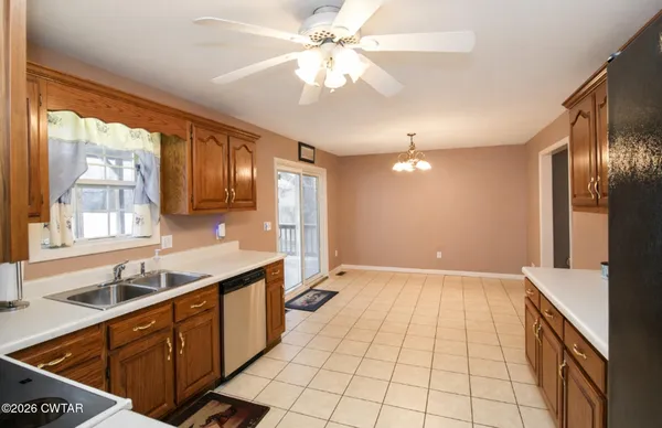 a kitchen with granite countertop a sink stainless steel appliances cabinets and a large window