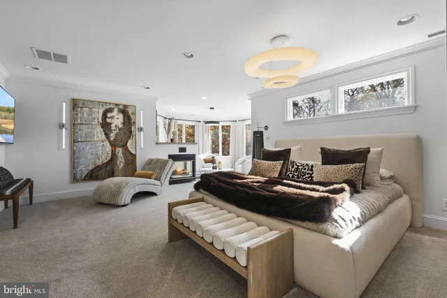 a living room with furniture a fireplace and a large window