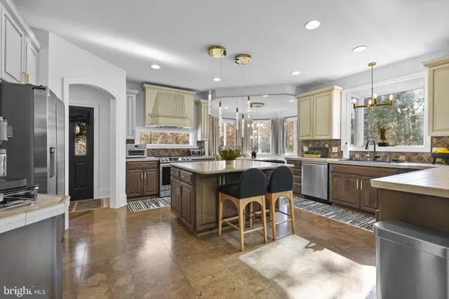 a kitchen with a sink refrigerator and chairs