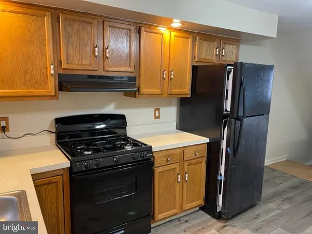 a kitchen with stainless steel appliances granite countertop a refrigerator stove and sink