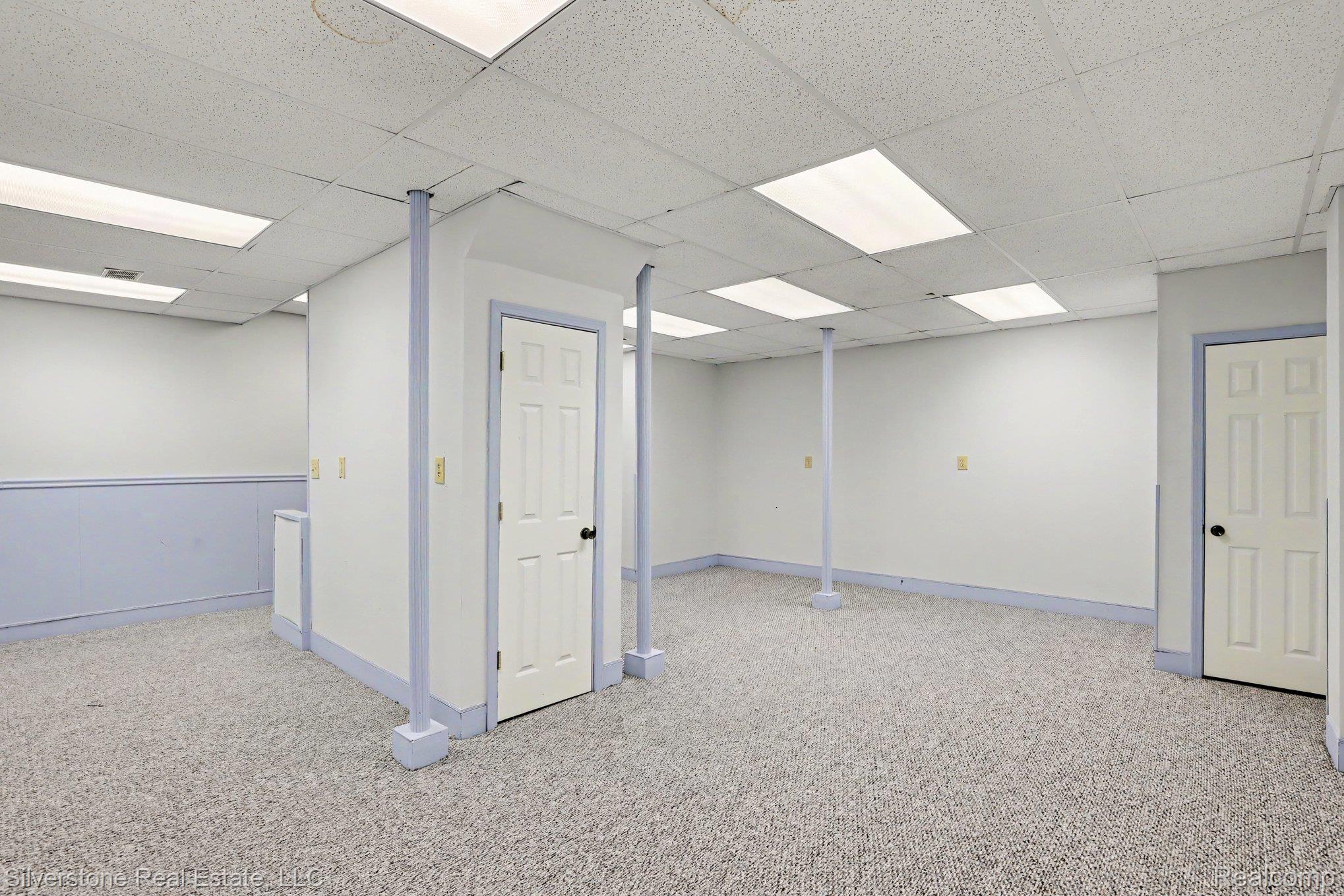 869 Timberline Drive Rochester, MI 48309 - Photo 23 of 29 Carpeted flooring, paneled interior doors, drop ceiling with integrated lighting, and walls with wainscoting