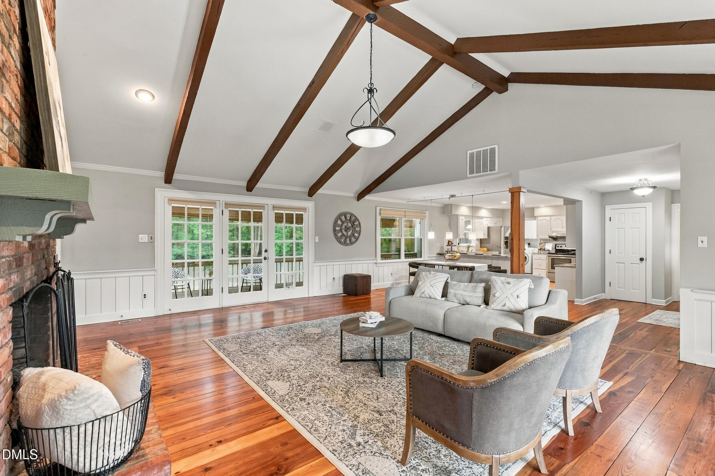 2329 Win Road Garner, NC 27529 - Photo 22 of 90 Vaulted ceiling with exposed wood beams, brick fireplace with wood mantel, wood-finish flooring, white paneling, and French doors