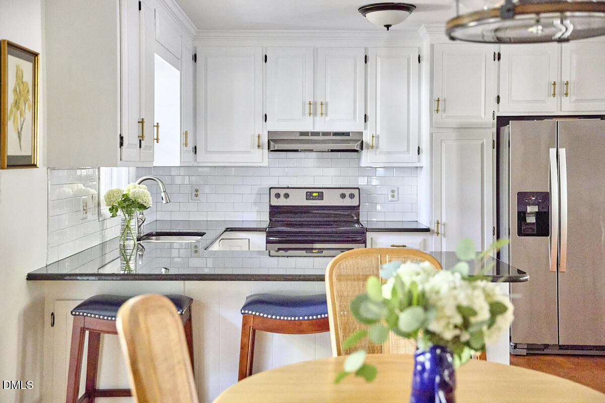 4916 Latimer Road Raleigh, NC 27609 - Photo 13 of 30 a kitchen with stainless steel appliances granite countertop a refrigerator and a stove
