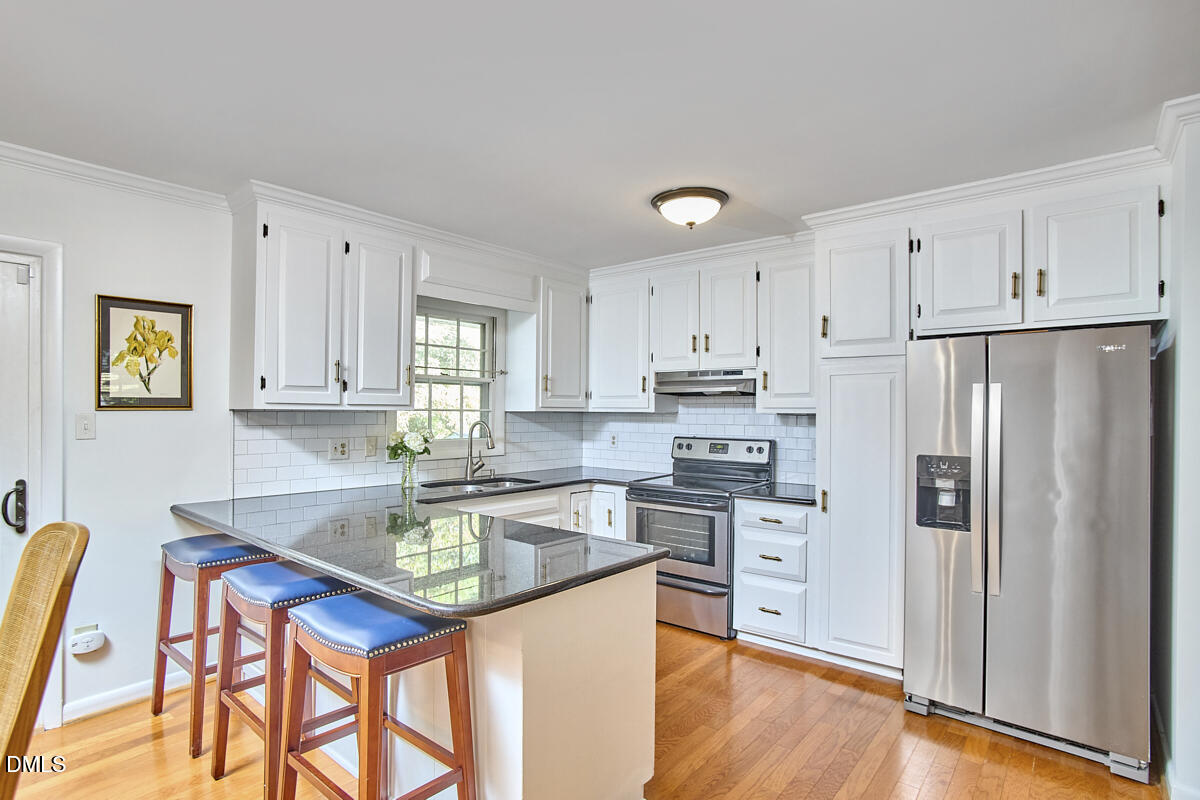 4916 Latimer Road Raleigh, NC 27609 - Photo 14 of 30 a kitchen with stainless steel appliances granite countertop a refrigerator sink and cabinets