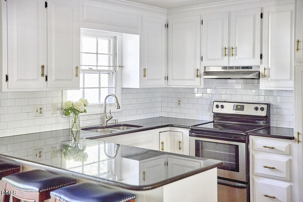 4916 Latimer Road Raleigh, NC 27609 - Photo 16 of 30 a kitchen with granite countertop a sink stainless steel appliances and cabinets