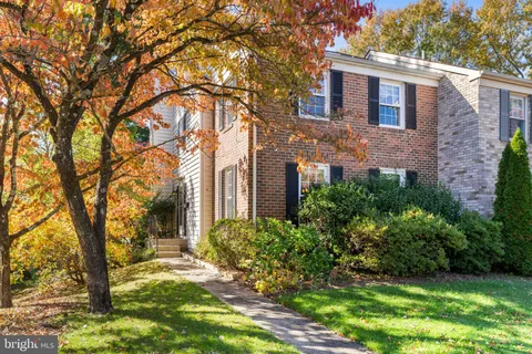 a view of a brick house with a large windows and a big yard