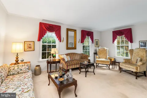 a living room with furniture kitchen view and a large window
