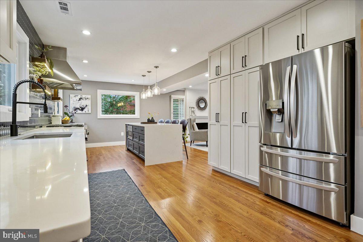 2111 Lirio Court Reston, VA 20191 - Photo 3 of 40 a kitchen with stainless steel appliances a refrigerator and wooden floor