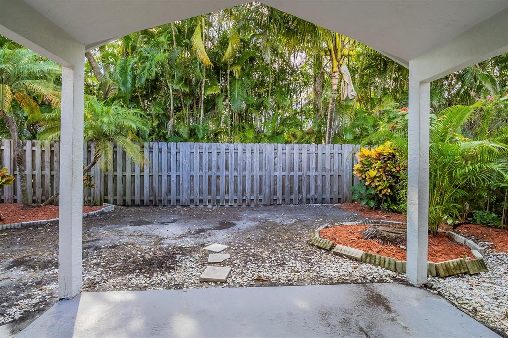 1875 Barnstable Road Wellington, FL 33414 - Photo 24 of 29 a backyard of a house with large trees and wooden fence