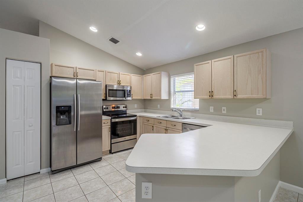 1875 Barnstable Road Wellington, FL 33414 - Photo 7 of 29 a kitchen with kitchen island a counter top space stainless steel appliances and cabinets