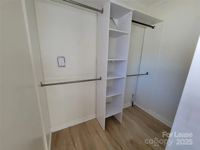 a view of walk in closet with wooden floor