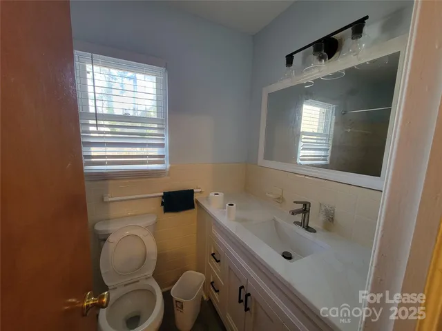 a bathroom with a sink mirror and toilet