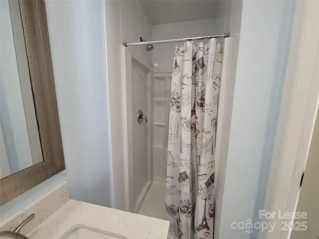 a bathroom with a shower curtain and a toilet