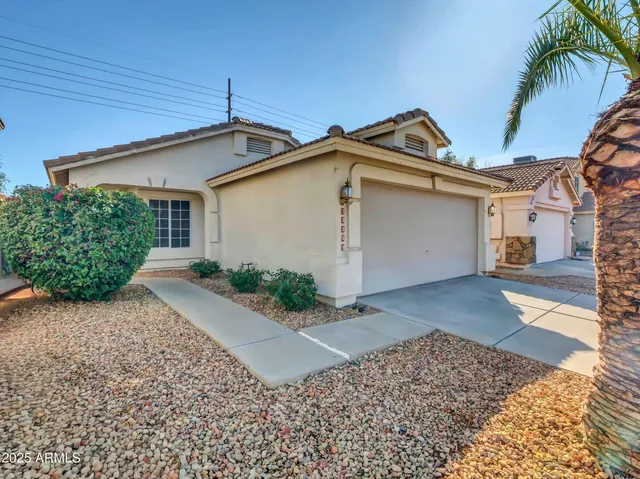 a view of a front of house with a yard and potted plants