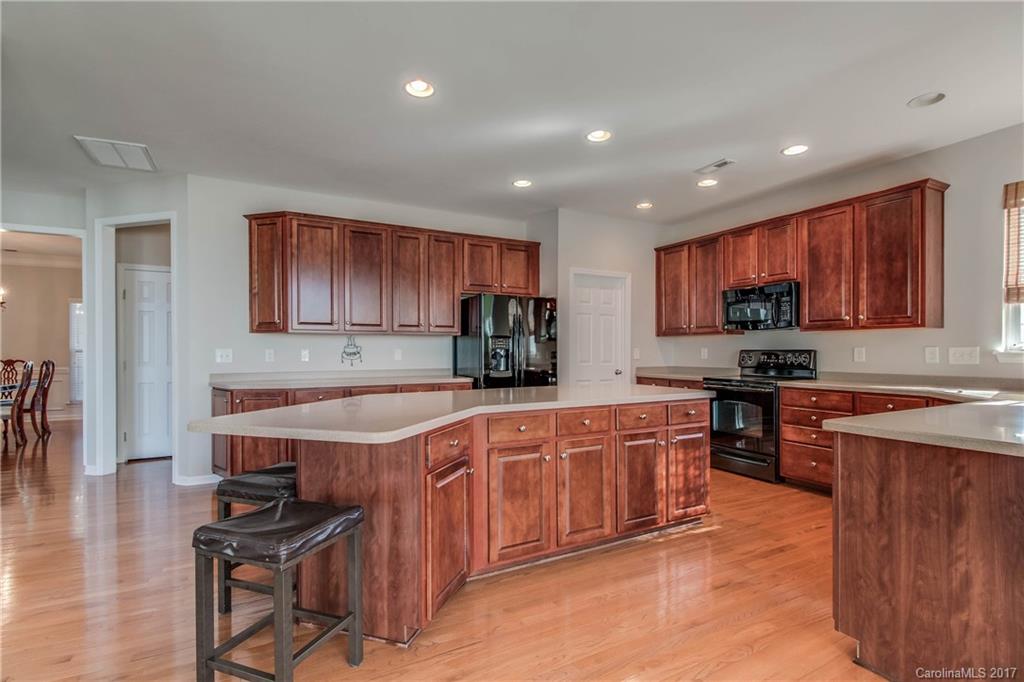 634 Panthers Way Fort Mill, SC 29708 - Photo 10 of 24 a kitchen with stainless steel appliances granite countertop a stove top oven a sink dishwasher and a refrigerator with wooden cabinets