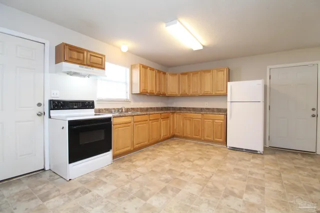 a kitchen with a cabinets and white appliances