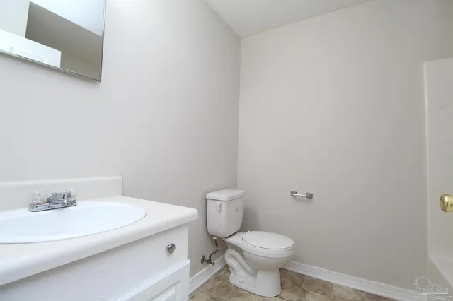 a white toilet sitting next to a bathroom sink