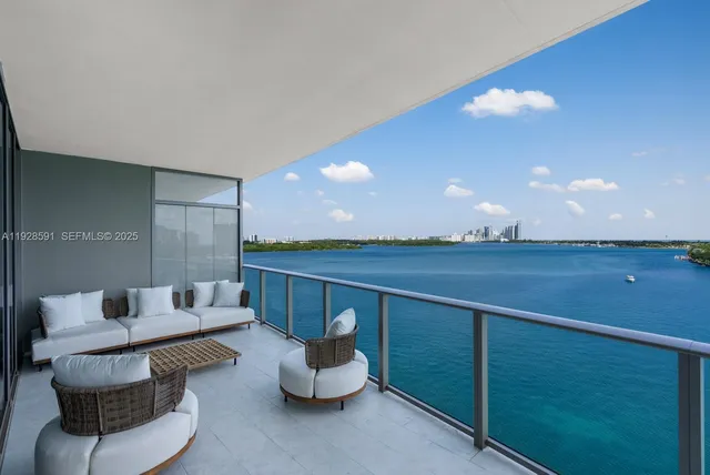 a living room with furniture a rug potted plant and a large window