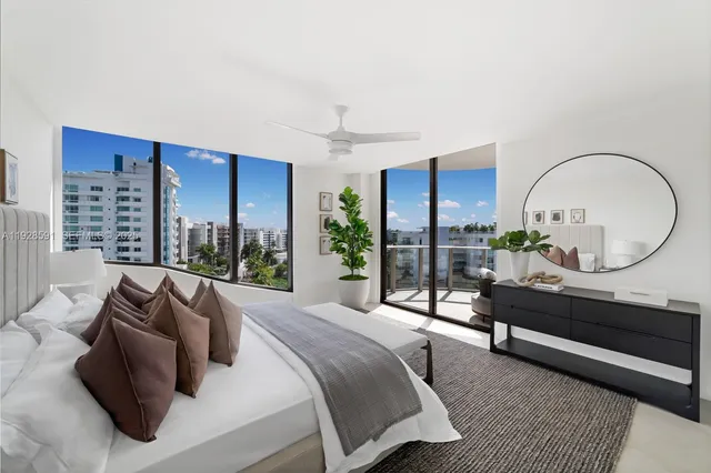 a bedroom with a large bed and a potted plant