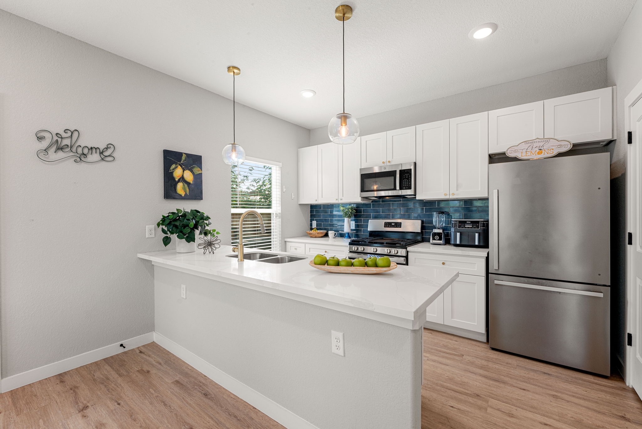 8357 Tate Street Houston, TX 77028 - Photo 14 of 42 a kitchen with a refrigerator a stove a microwave and wooden floor