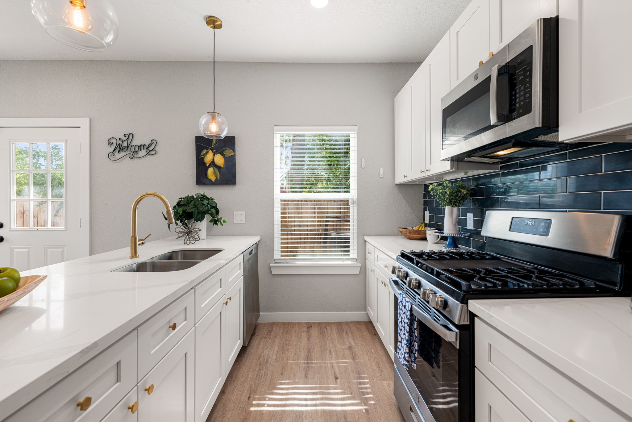 8357 Tate Street Houston, TX 77028 - Photo 17 of 42 a kitchen with stainless steel appliances a stove sink microwave and cabinets