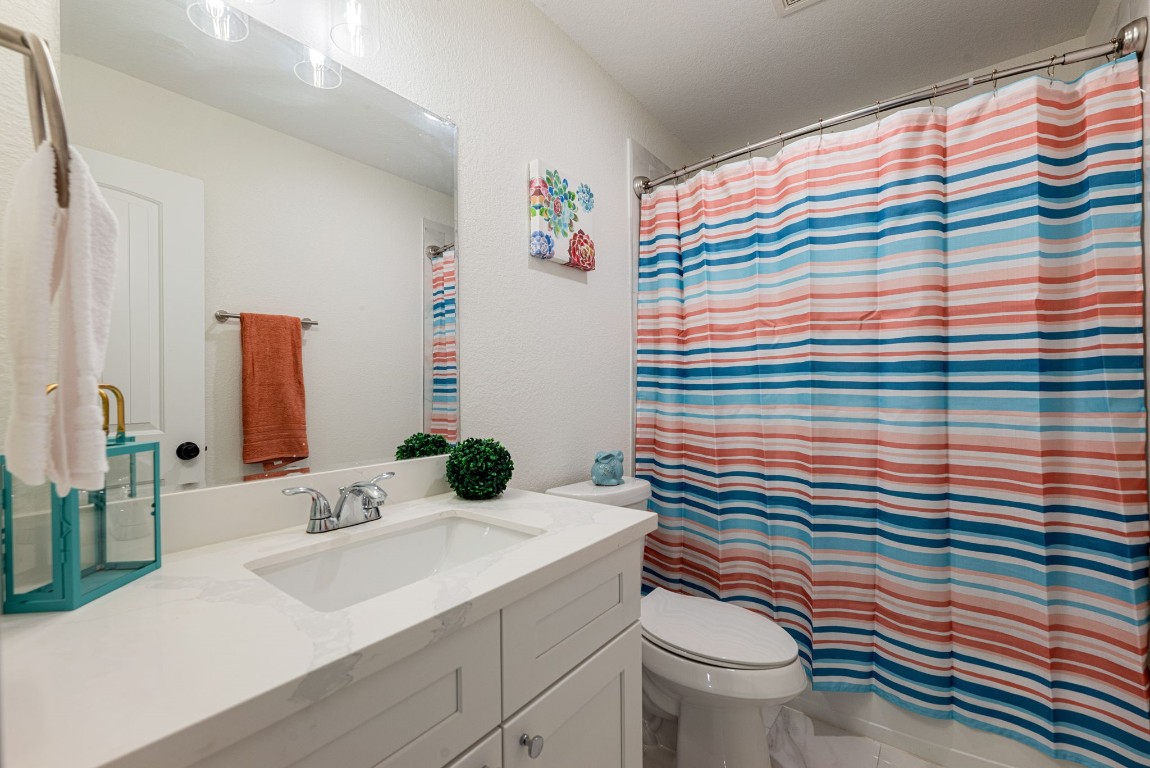 8357 Tate Street Houston, TX 77028 - Photo 23 of 40 a bathroom with a sink a toilet and shower curtain
