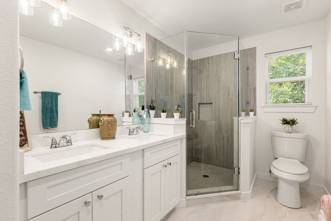 8357 Tate Street Houston, TX 77028 - Photo 26 of 40 a bathroom with a toilet a sink a shower and a mirror
