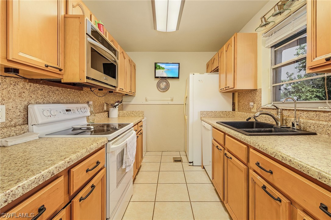 8185 Egret Road Fort Myers, FL 33967 - Photo 15 of 35 a kitchen with stainless steel appliances granite countertop a sink and a stove