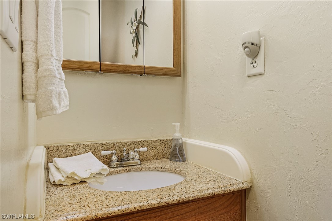 8185 Egret Road Fort Myers, FL 33967 - Photo 20 of 35 a bathroom with a granite countertop sink and a mirror