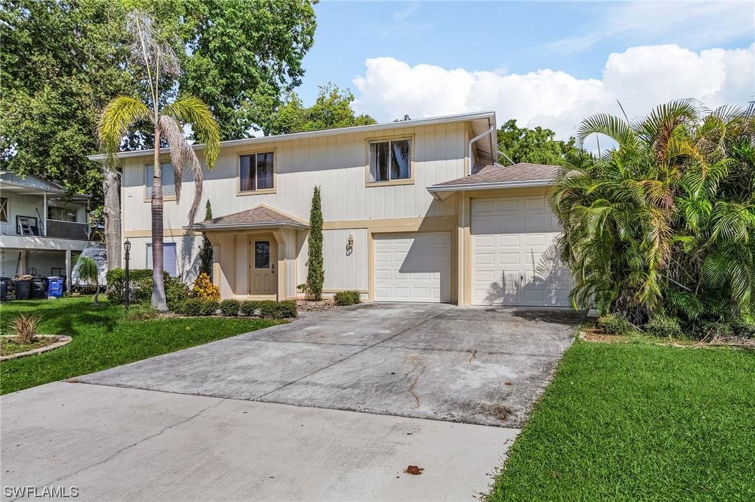 8185 Egret Road Fort Myers, FL 33967 - Photo 2 of 35 a view of a white house with a yard and plants