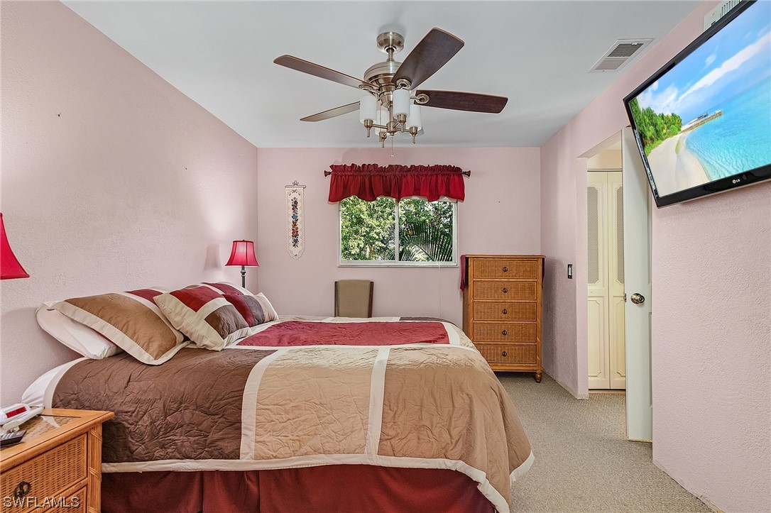 8185 Egret Road Fort Myers, FL 33967 - Photo 22 of 35 a bedroom with a bed and a chandelier
