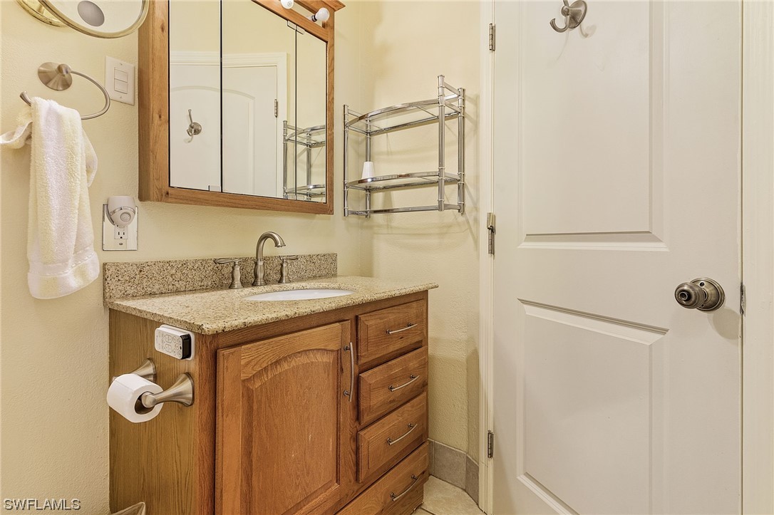 8185 Egret Road Fort Myers, FL 33967 - Photo 23 of 35 a bathroom with a granite countertop sink and a mirror