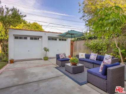 a view of a chair and tables in the back yard of the house