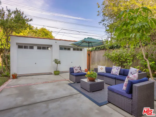 a view of a chair and tables in the back yard of the house