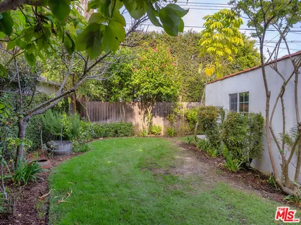 a view of backyard with table and chairs and potted plants