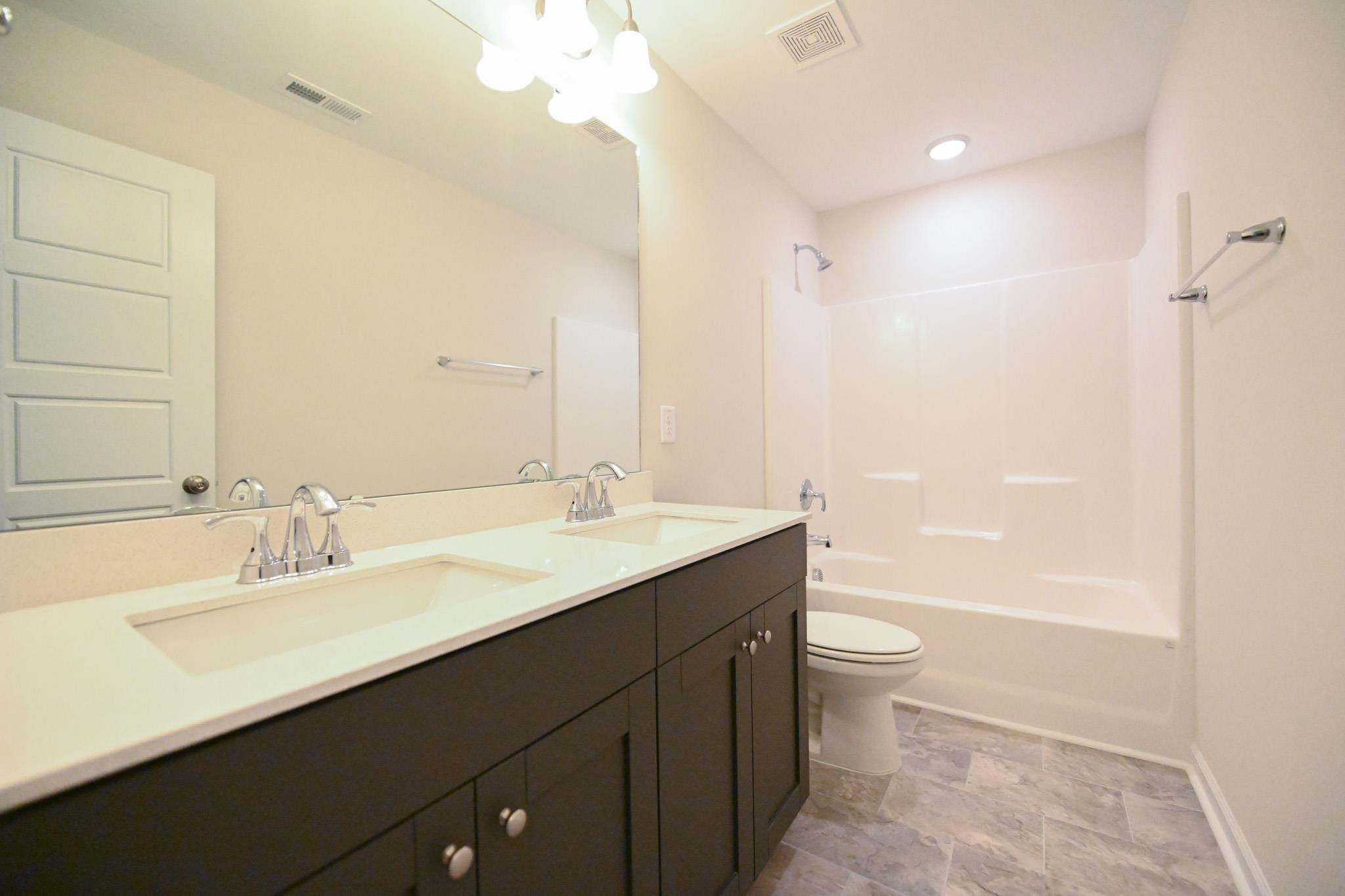 1701 Ramsdale Road Hope Mills, NC 28348 - Photo 21 of 25 a bathroom with a double vanity sink toilet and shower