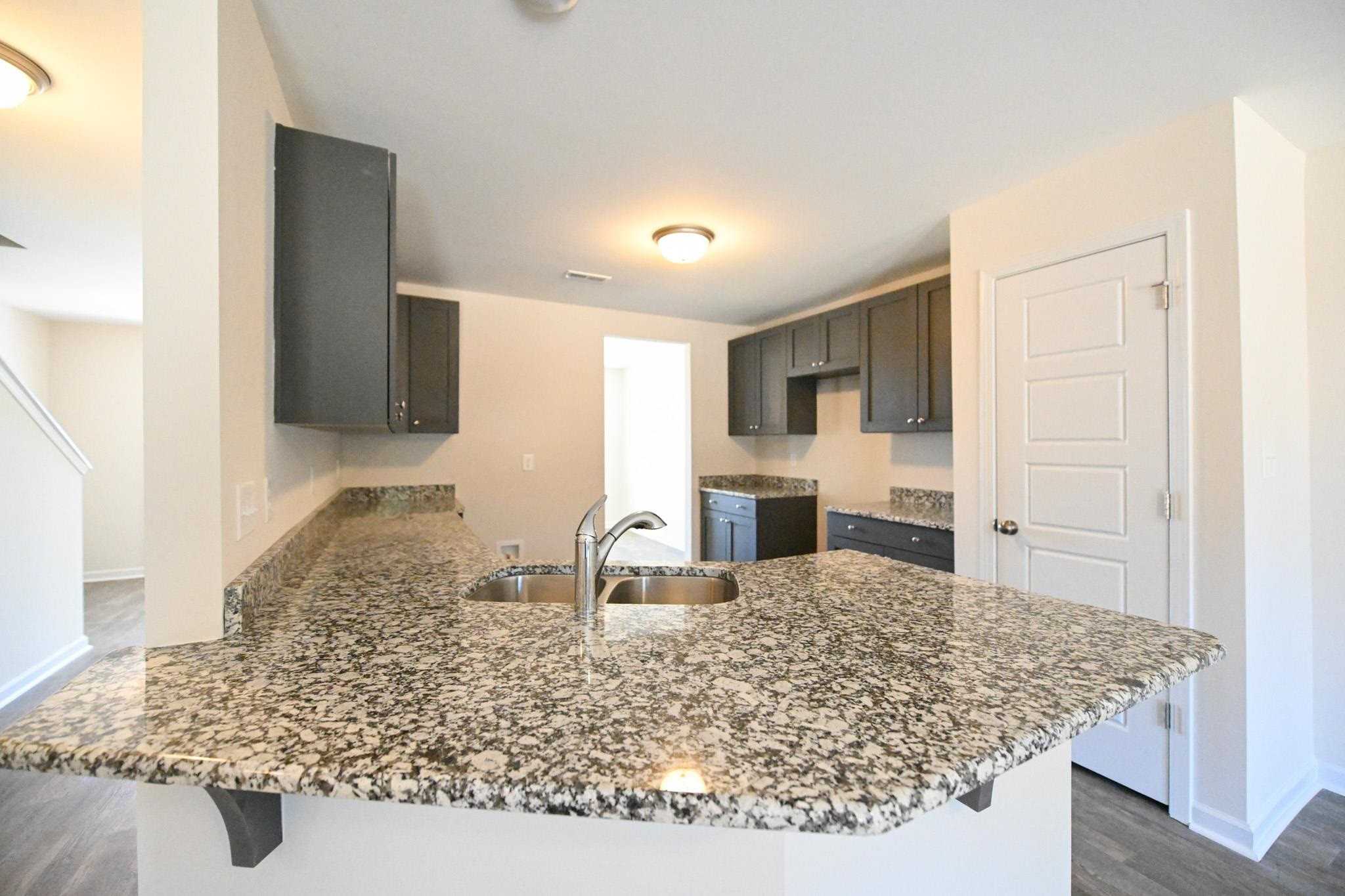 1701 Ramsdale Road Hope Mills, NC 28348 - Photo 9 of 25 a kitchen with kitchen island sink stove and granite counter top