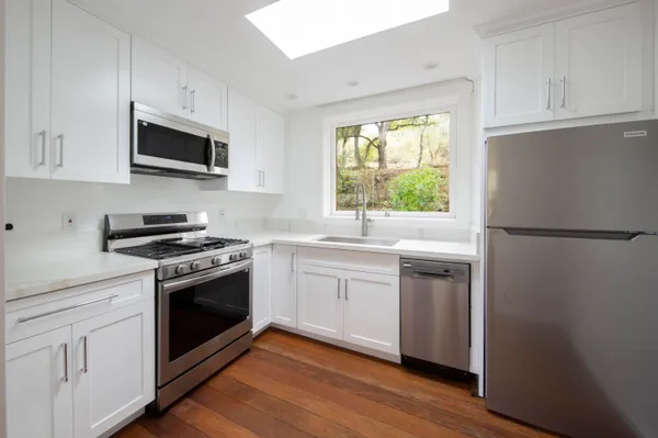 a kitchen with white cabinets and appliances