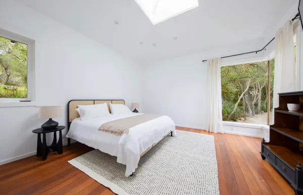 a bedroom with a bed wooden floor and a window