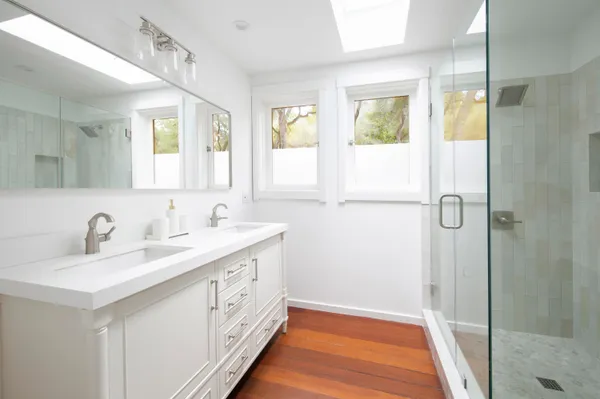 a bathroom with a double vanity sink a mirror and a shower