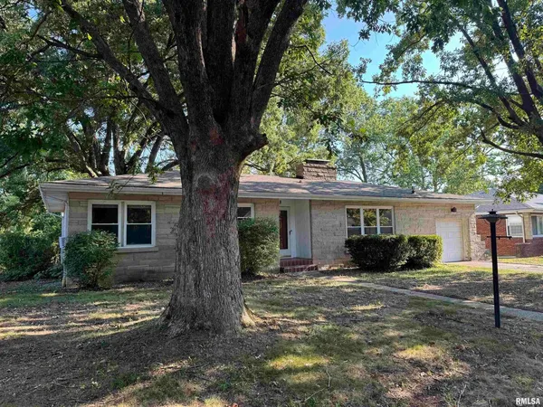 a view of house with outdoor space and trees in the background