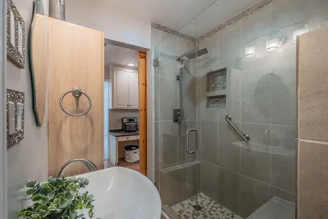 a bathroom with a granite countertop shower a mirror and a sink