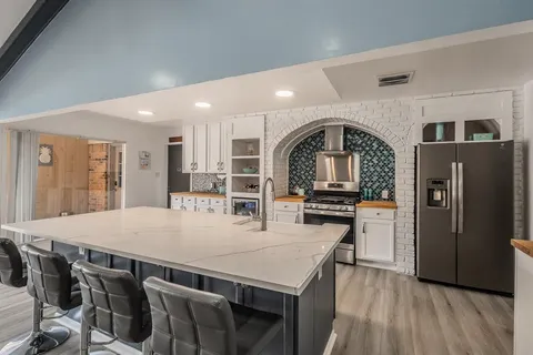 a view of kitchen with refrigerator microwave and stove