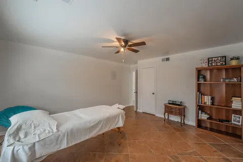 a bedroom with a bed and a book shelf