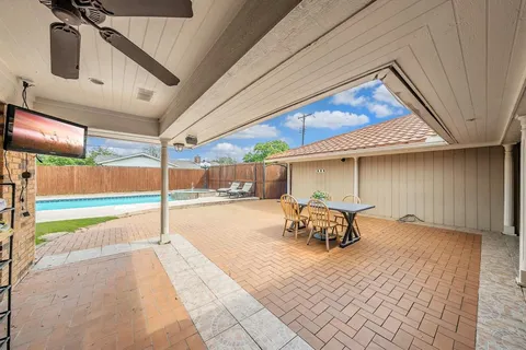 a view of a patio with table and chairs next to a yard