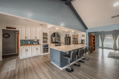 a large white kitchen with a large counter top and stainless steel appliances